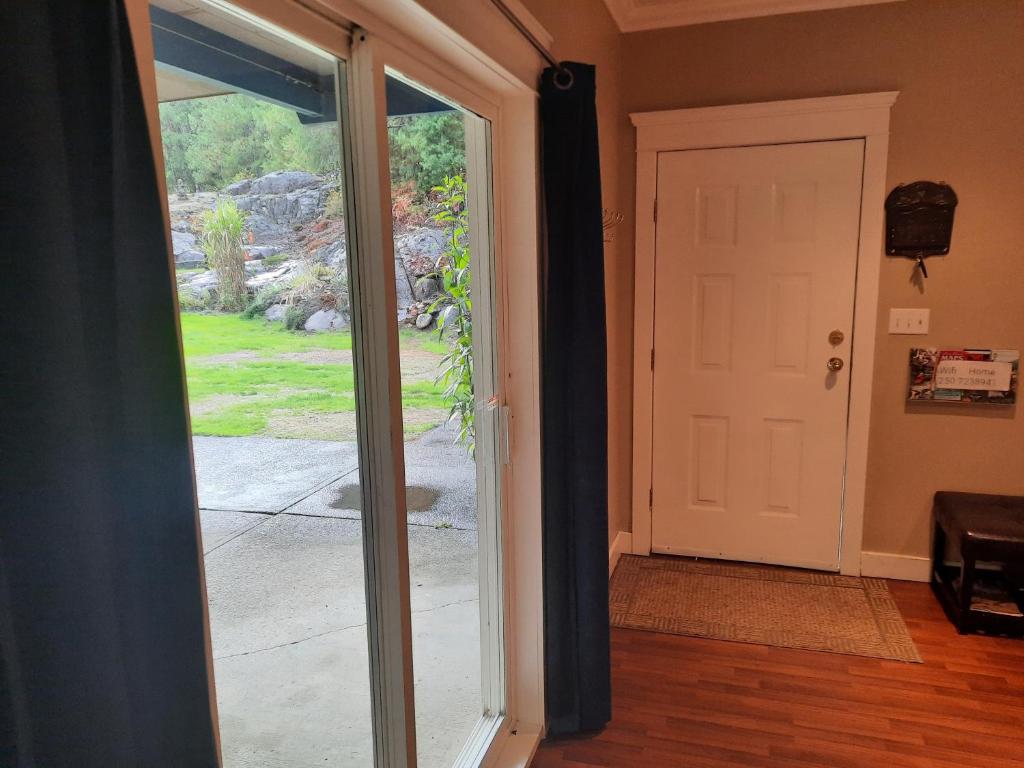 an open sliding glass door with a view of a yard at Beaver Hut Bed And Breakfast in Port Alberni