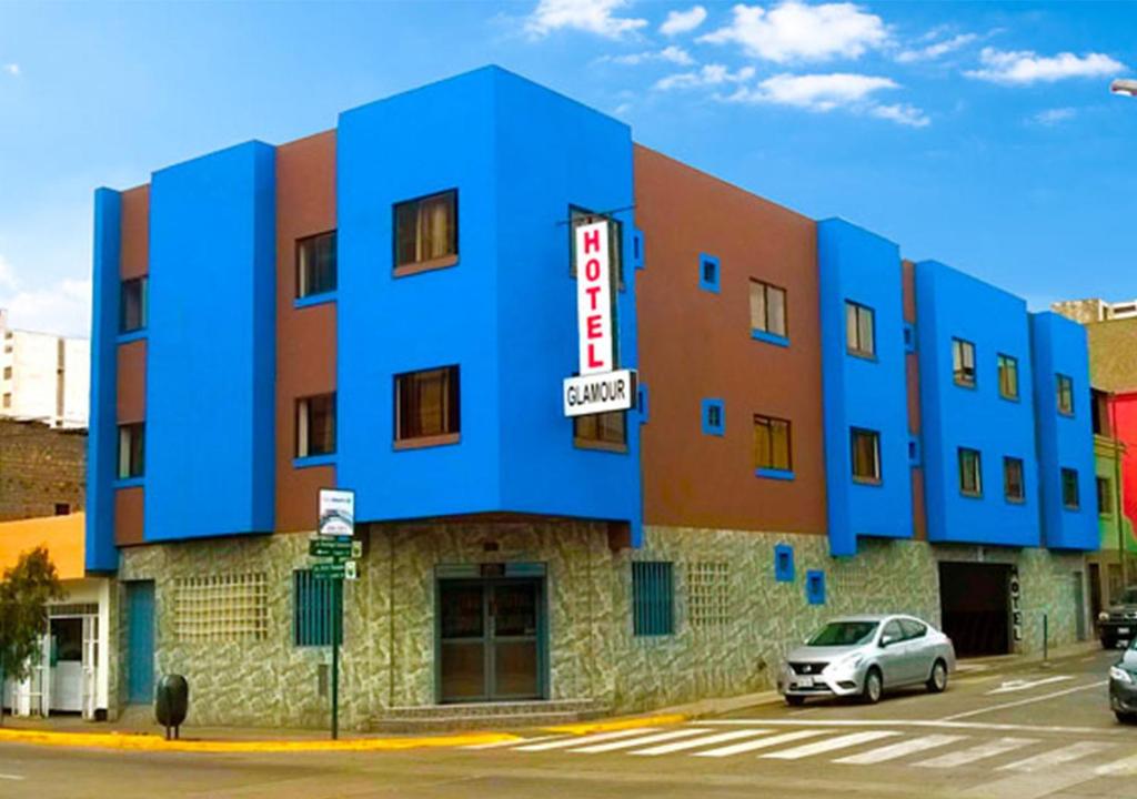 ein blaues Gebäude mit einem davor geparkt in der Unterkunft HOTEL GLAMOUR in Lima