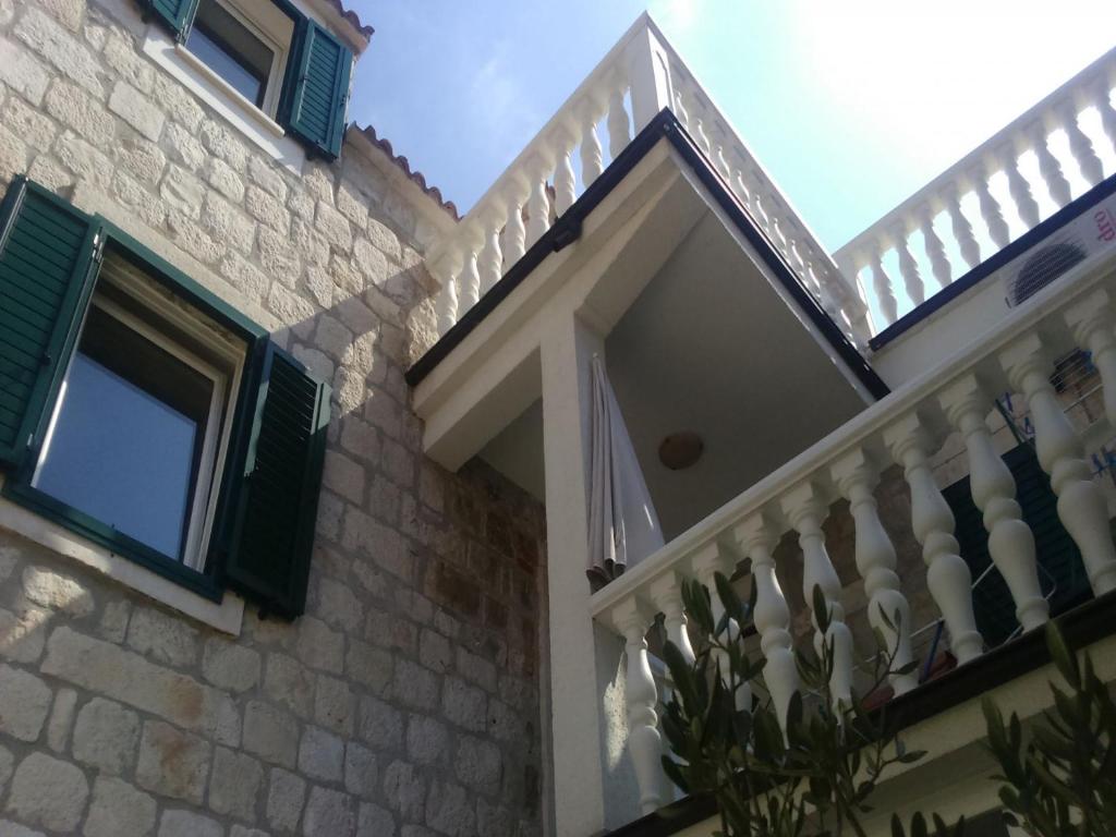 a house with a white fence and a balcony at Apartments Villa Mirakul in Kaštela