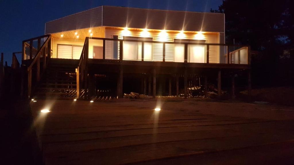 Una casa iluminada por la noche con luces encendidas en Costa Lobo en Pichilemu