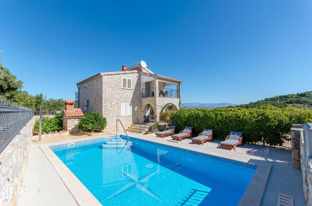 a swimming pool in front of a house at Apartment Jakov in Rogač