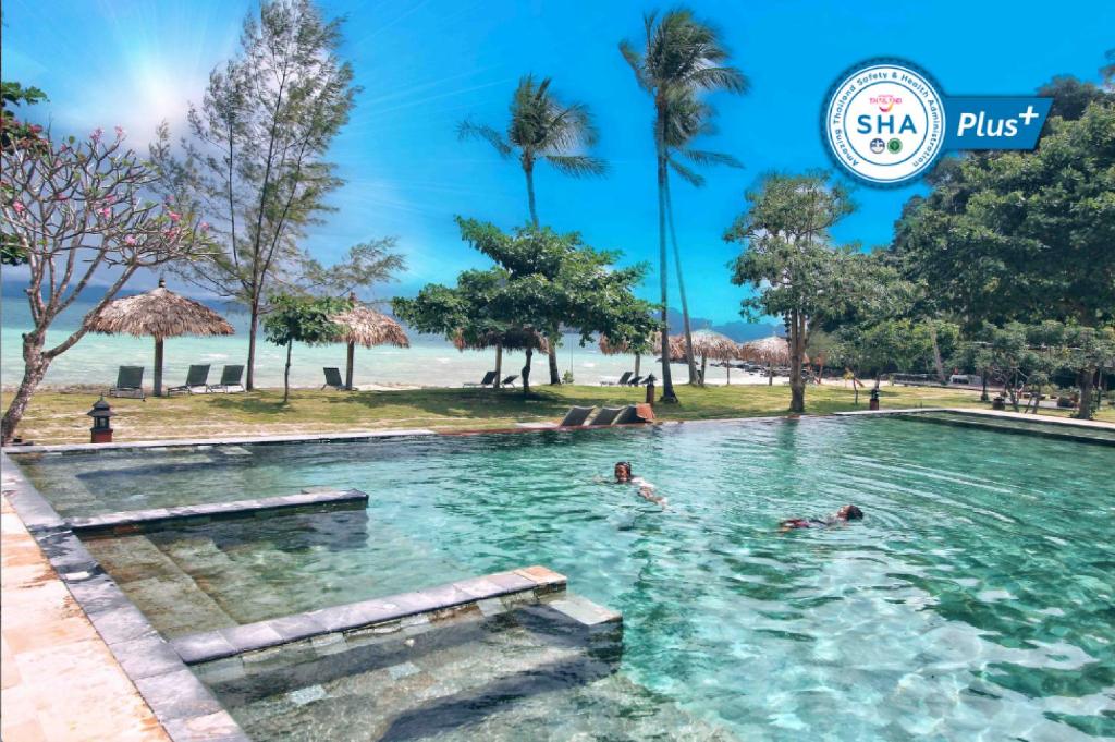 a swimming pool at a resort with people in the water at Thanya Beach Resort - SHA Plus in Ko Ngai