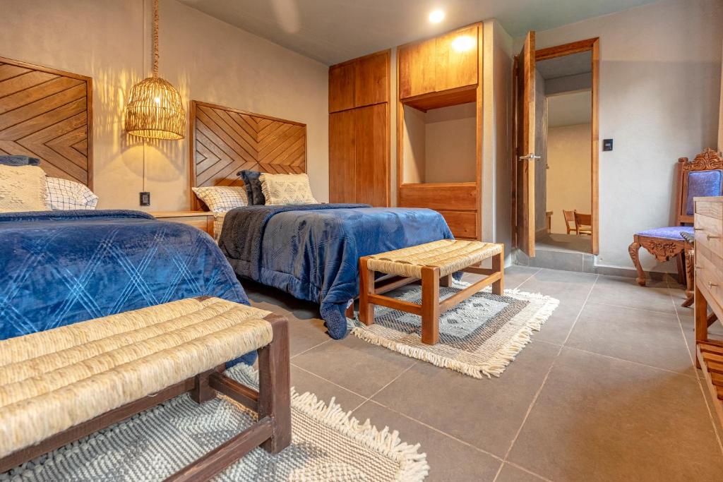 a bedroom with two beds and a table at Casa Lavanda Hotel Boutique in P&aacute;tzcuaro