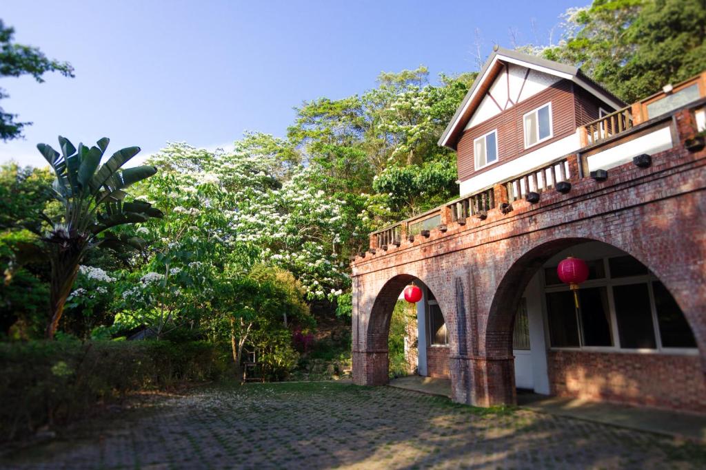 三義鄉的住宿－福田瓦舍Futen Villa，树旁有拱门的砖砌建筑