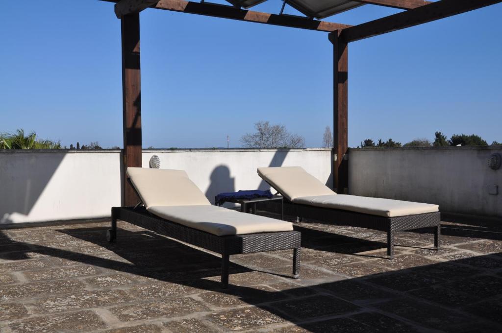 タヴィアーノにあるCorte degli Aranci Casa Vacanzeのパティオに座るベッド1台