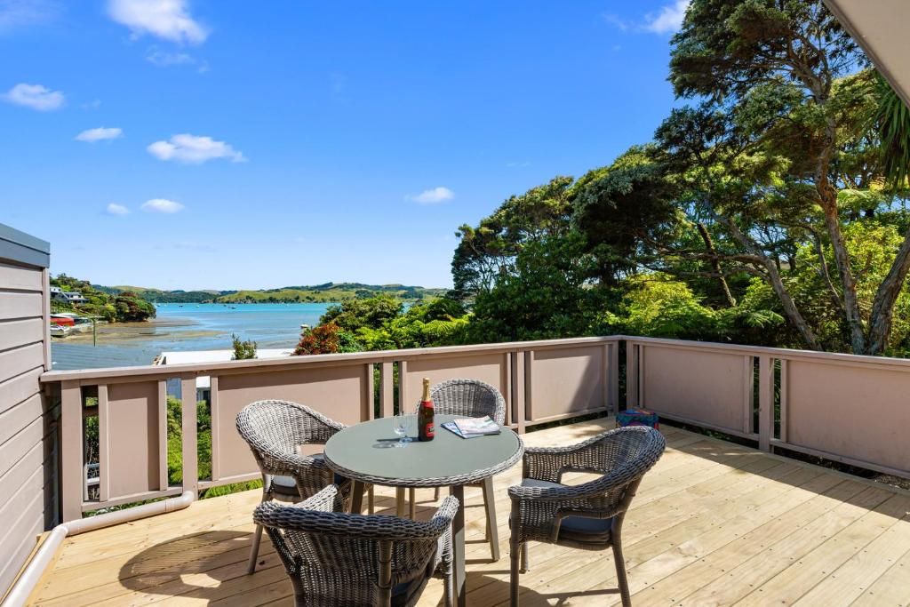a patio with a table and chairs on a deck at Greenslade Canopy - Raglan Holiday Home in Raglan