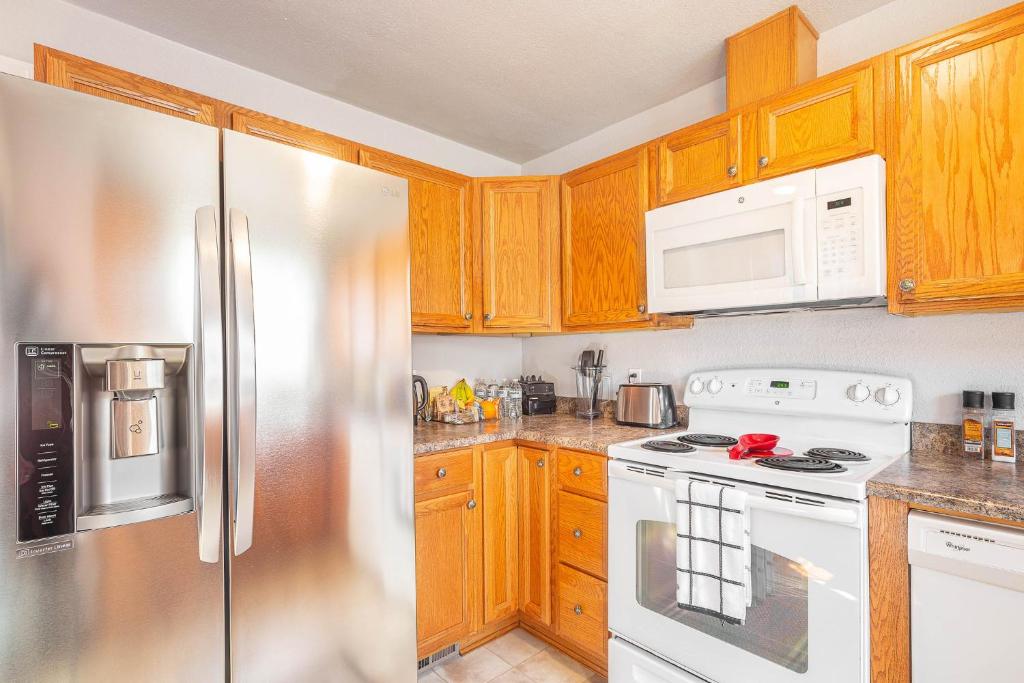 a kitchen with wooden cabinets and a stainless steel refrigerator at Duplex in Alberta Art District in Portland
