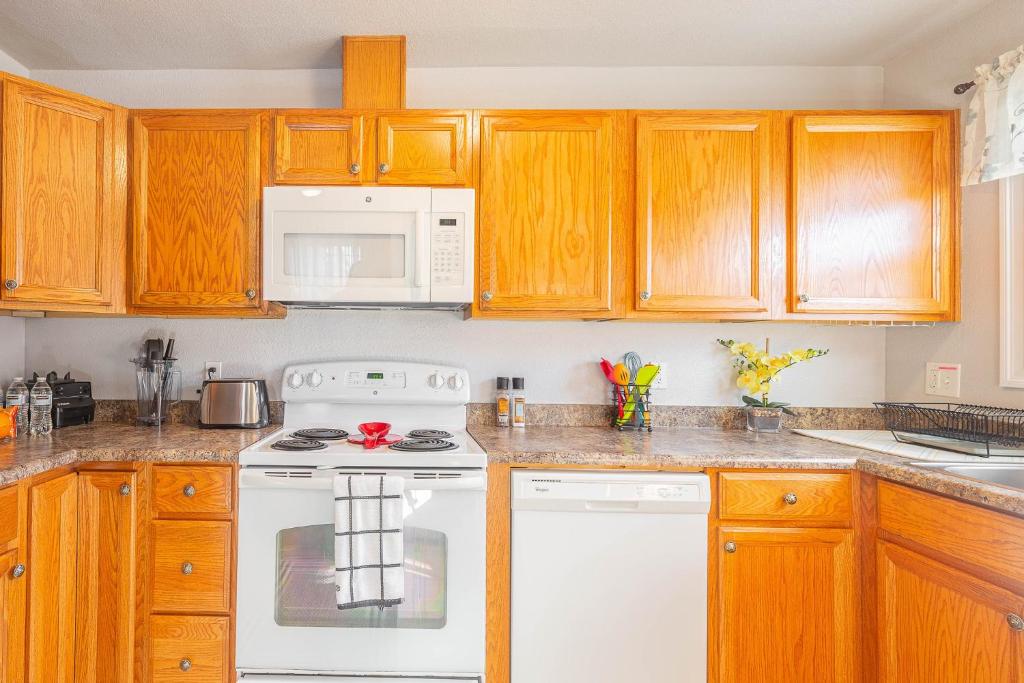 a kitchen with wooden cabinets and a white stove top oven at Duplex in Alberta Art District in Portland