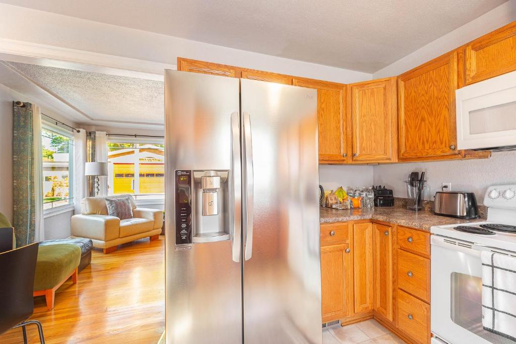a kitchen with wooden cabinets and a stainless steel refrigerator at Duplex in Alberta Art District in Portland
