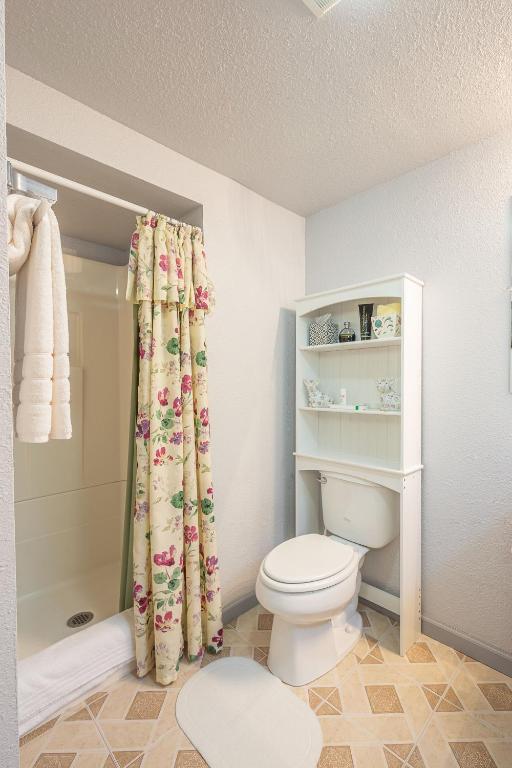 a bathroom with a toilet and a shower curtain at Duplex in Alberta Art District in Portland