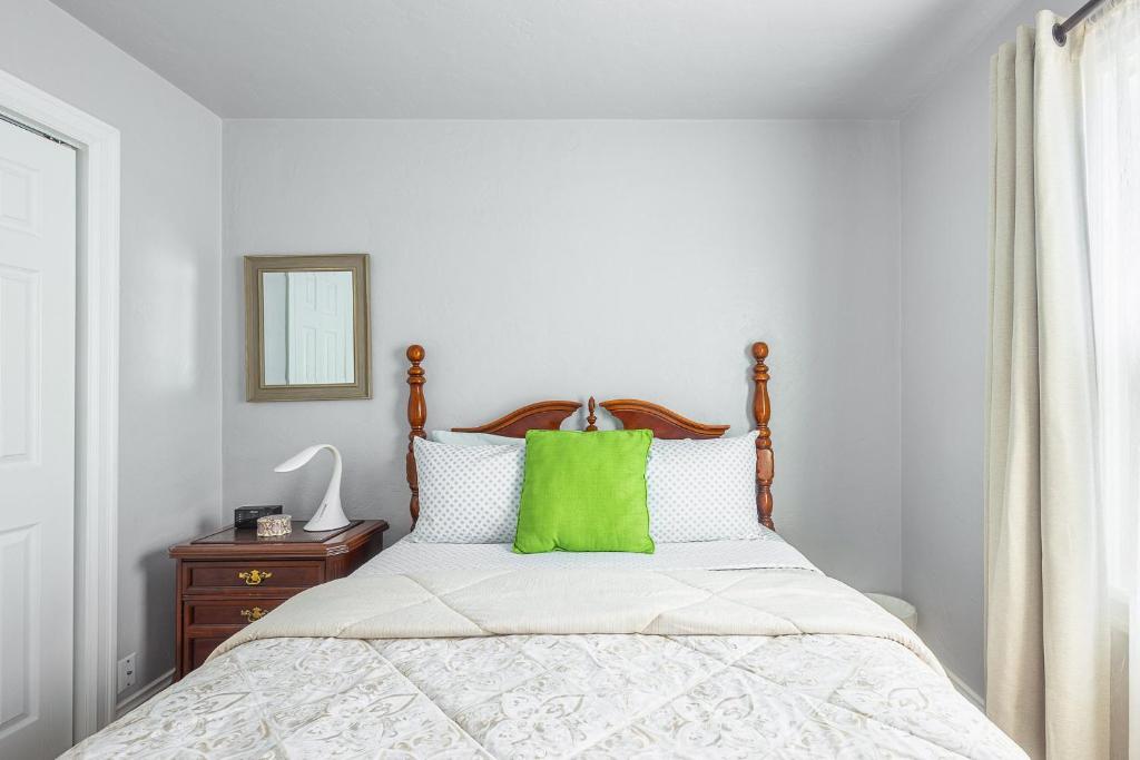a bedroom with a bed with a green pillow on it at Duplex in Alberta Art District in Portland