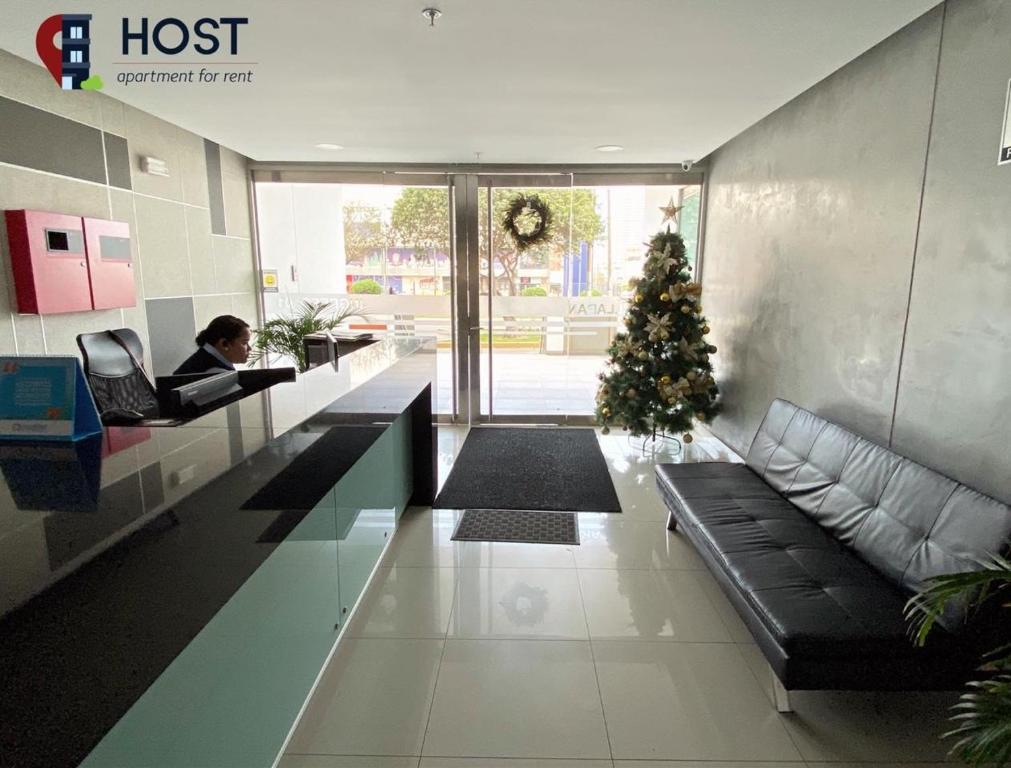 a woman sitting in a lobby with a christmas tree at Host - San Isidro Sta Catalina in Lima