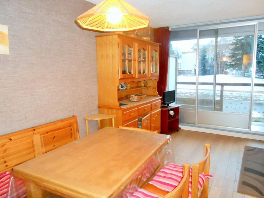 a kitchen with a wooden table and a dining room at Studio Les Deux Alpes, 1 pièce, 4 personnes - FR-1-516-55 in Les Deux Alpes