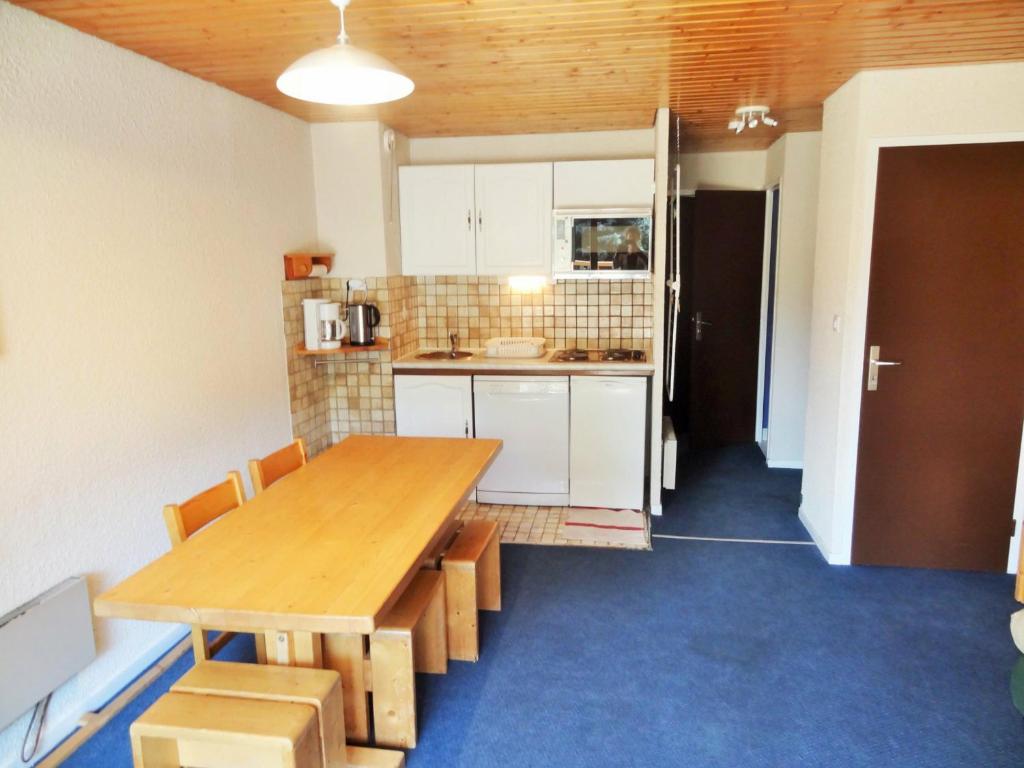 uma cozinha com uma mesa de madeira num quarto em Appartement Les Deux Alpes, 2 pièces, 4 personnes - FR-1-516-66 em Les Deux Alpes