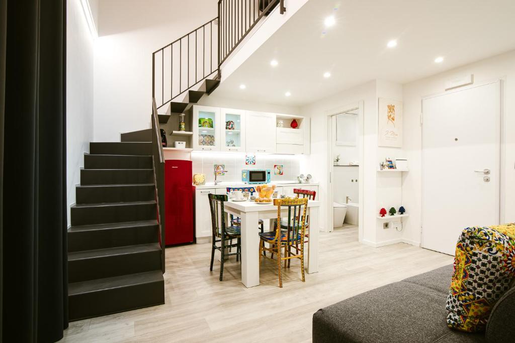 a living room with a staircase and a kitchen with a table at Il Moro Boutique Apartment in Catania