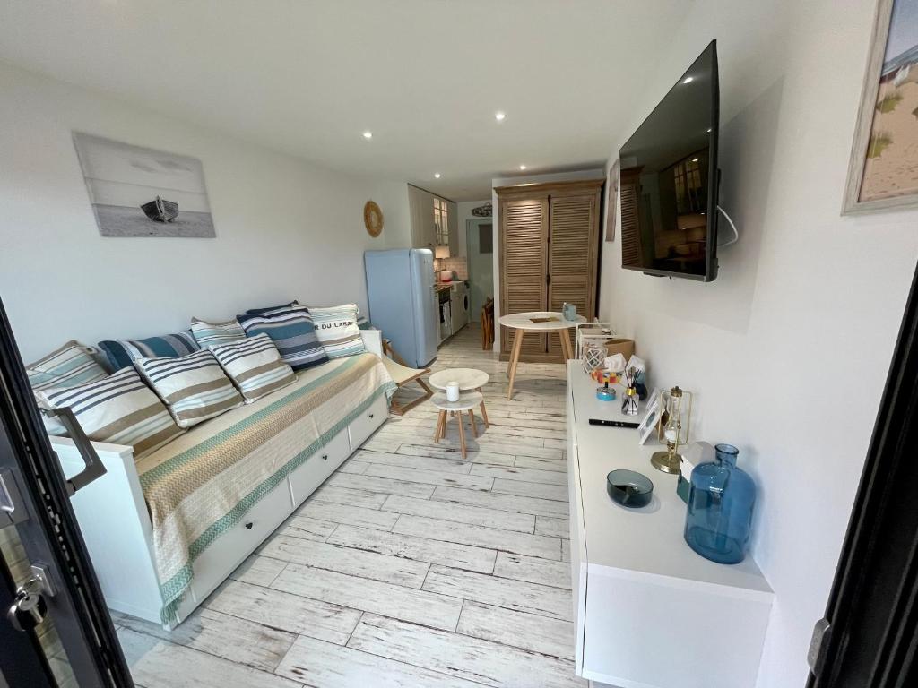 Una pequeña habitación con una cama y un televisor. en Studio cosy en bord de mer, en Sangatte