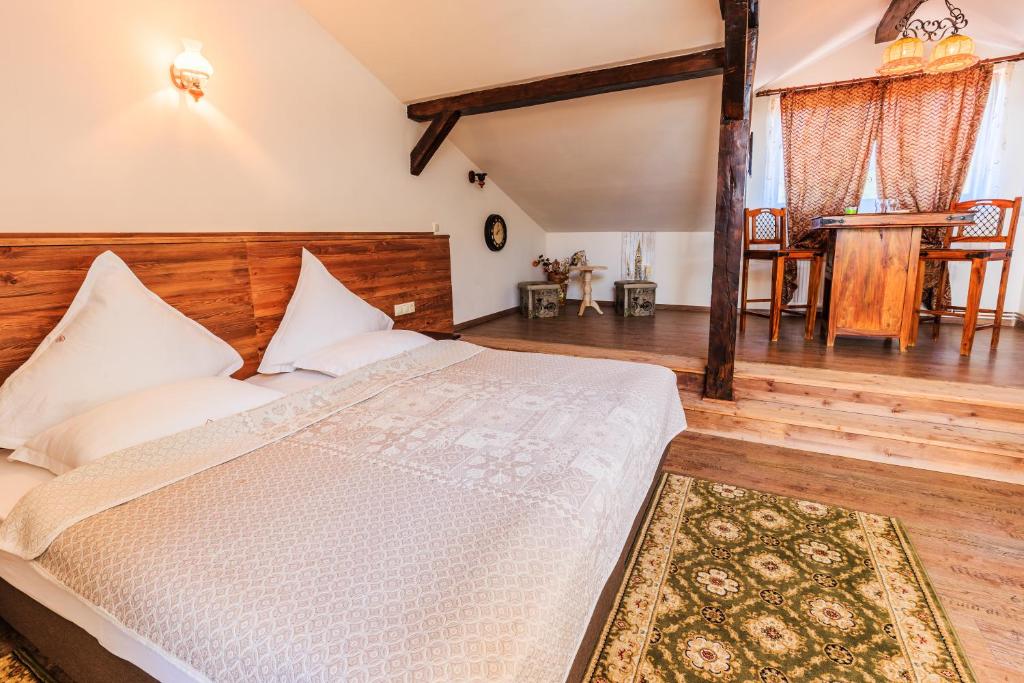 1 dormitorio con 1 cama grande y cabecero de madera en Hotel Bielmann en Sînpetru