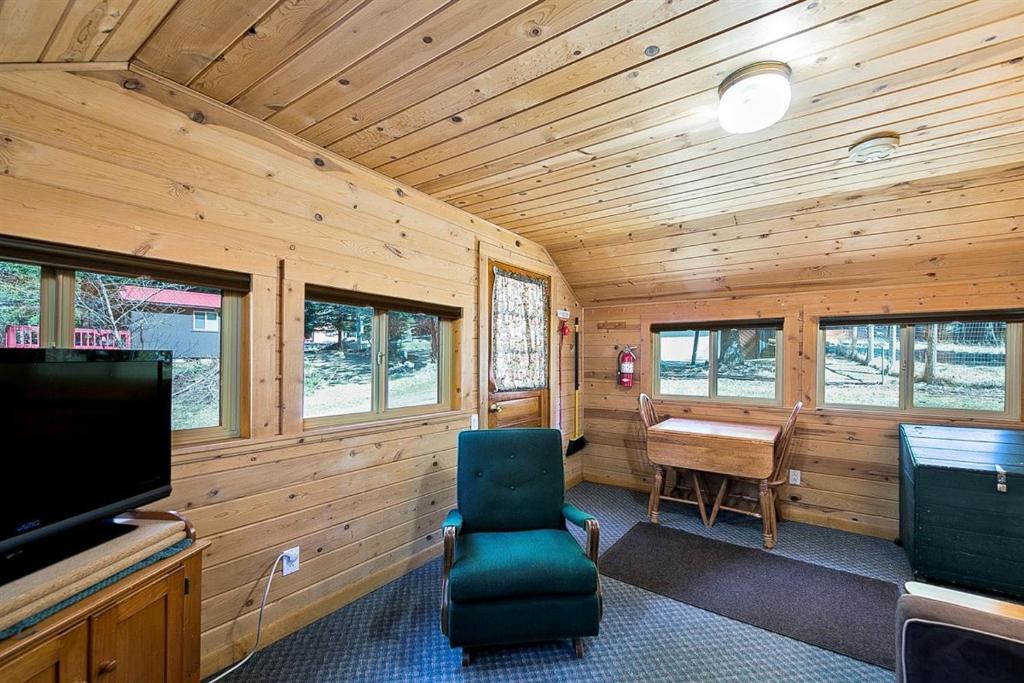 Joseph的住宿－Mount Bonneville，客房设有电视、椅子和书桌。