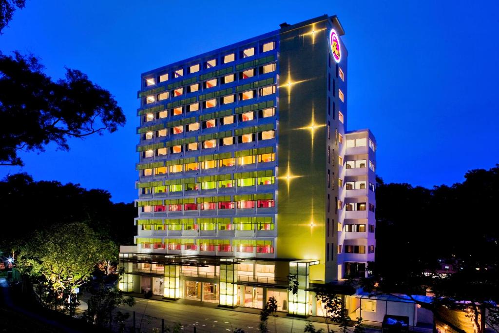 a tall building with lights on it at night at Hotel Re! @ Pearl's Hill in Singapore