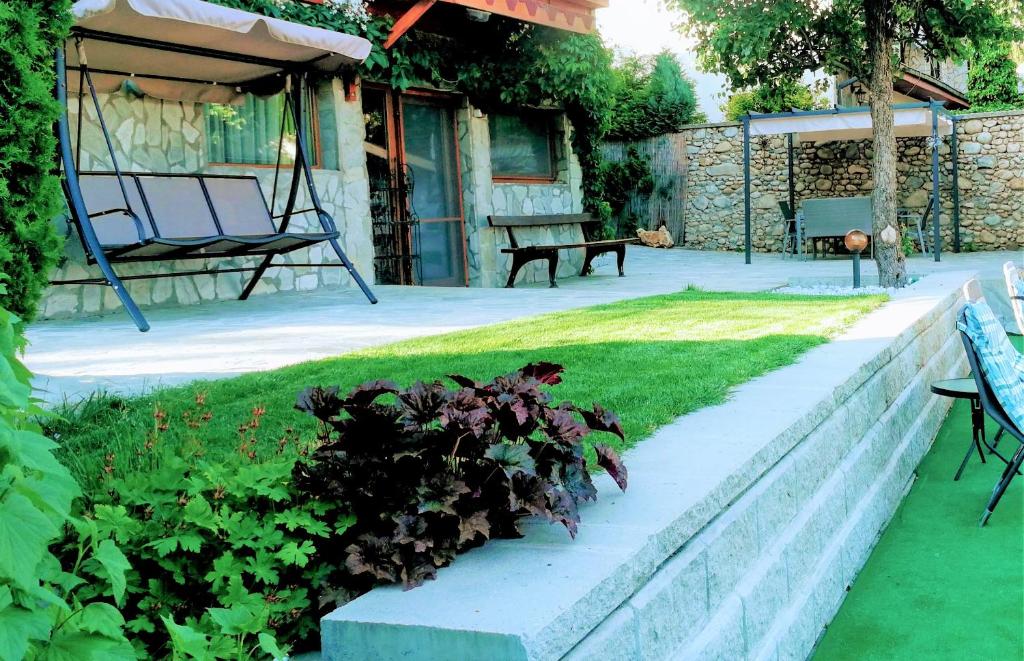 a garden with a retaining wall and a bench at Apartment Bankya in Bankya