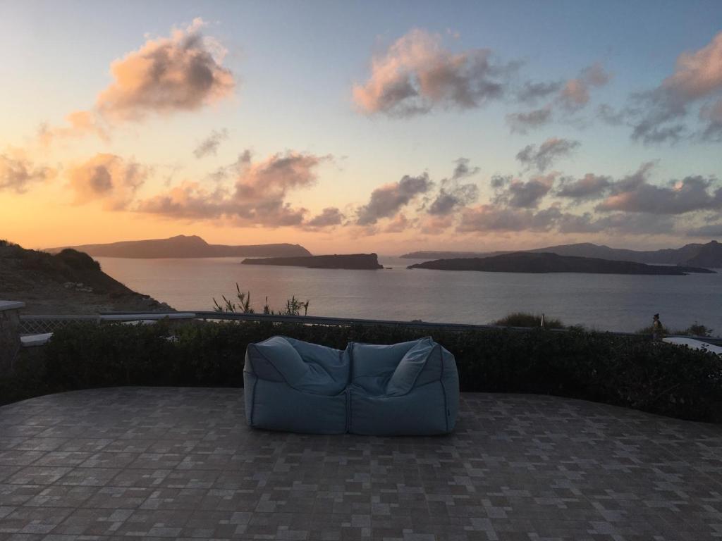 a blue couch sitting on a patio near the water at Modus Vivendi Villas in Akrotiri