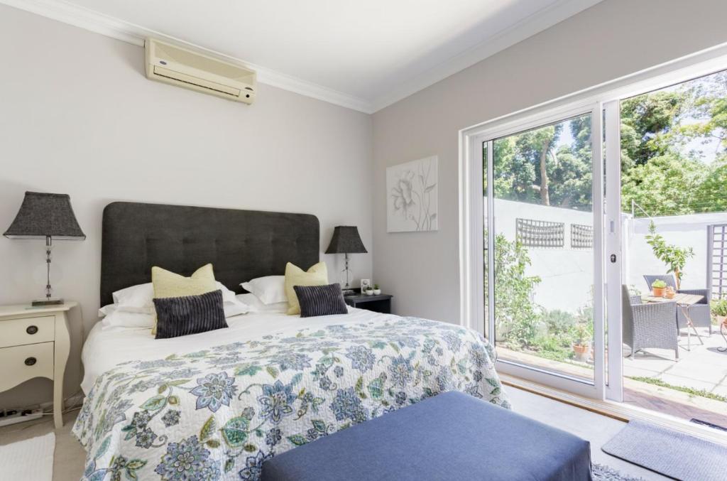 a bedroom with a bed and a large window at 18 Abbotsford in Cape Town