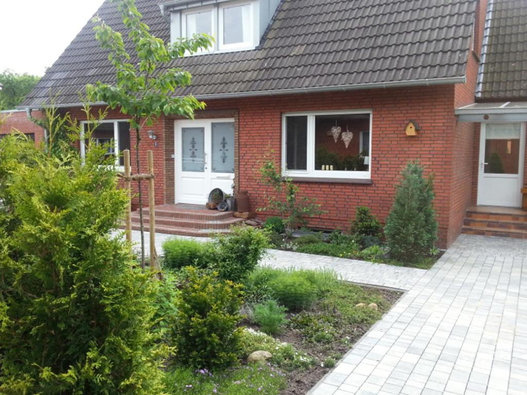 une maison en briques rouges avec un jardin en face de celle-ci dans l'établissement Ferienhaus Emstal in Oberlangen, à Lathen