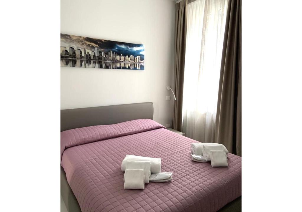 een slaapkamer met een paars bed met 2 handdoeken erop bij Delizioso appartamento in villa al mare in Pesaro