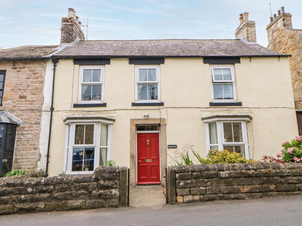 a white house with a red door at Bellevue in Barnard Castle