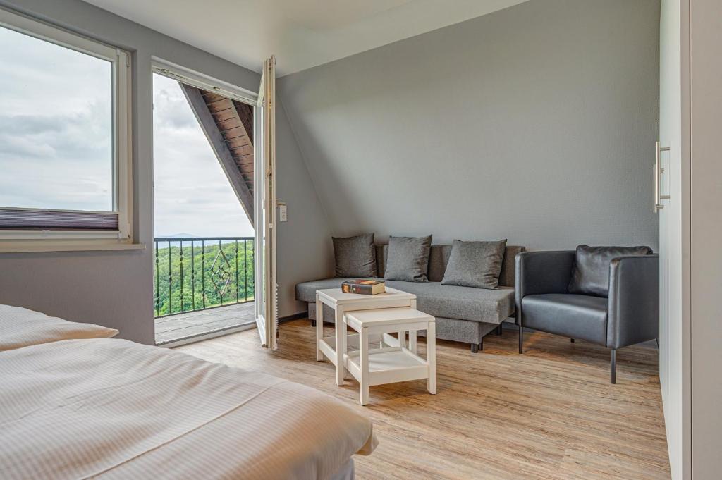 a bedroom with a bed and a couch and a window at Ferienhaus Hohe Klinge in Brotterode-Trusetal