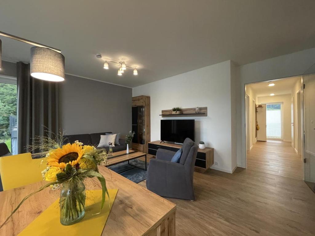 a living room with a vase of flowers on a table at Sonnenweg 46-6 WILDE 13 in Heringhausen