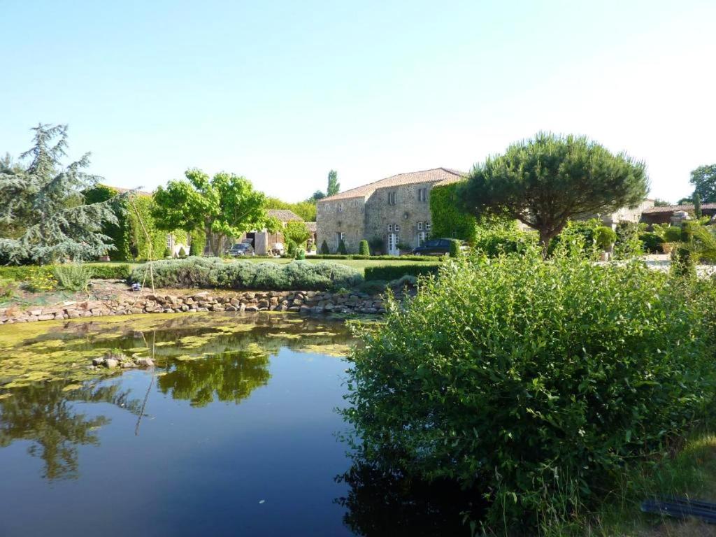 a garden with a pond in front of a building at Maison charmante à Landevieille avec jardin clos in Landevieille
