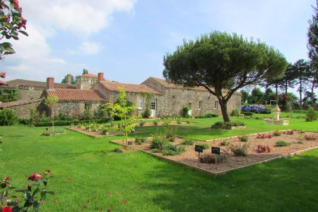 a garden in front of a large stone building at Maison spacieuse proche du centre de Landevieille + jardin clôturé in Landevieille