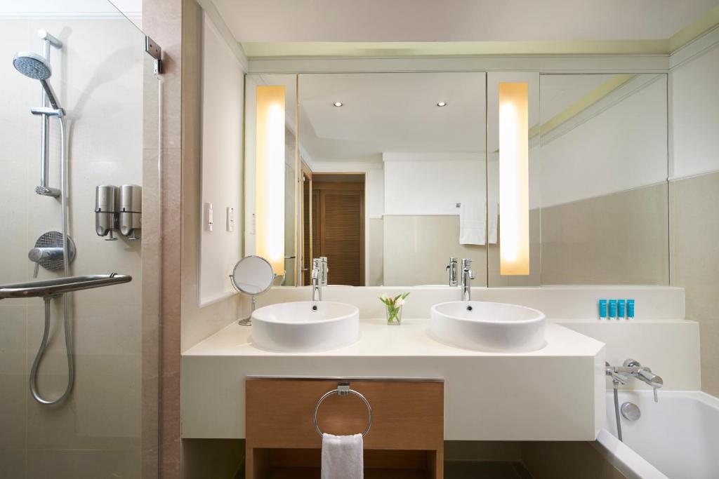 a bathroom with two sinks and a mirror at Amari Bangkok in Bangkok