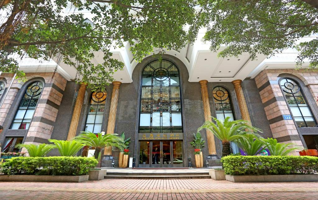 a building with large windows and plants in front of it at Grand Palace Hotel - Grand Hotel Management Group in Guangzhou