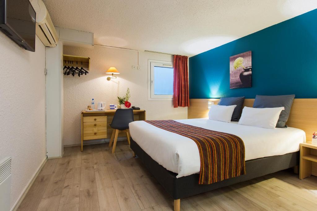 Pokój hotelowy z dużym łóżkiem i biurkiem w obiekcie Comfort Hotel Montlucon w mieście Montluçon