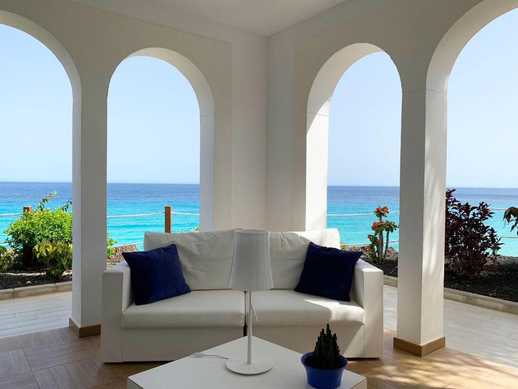 a living room with a white couch and the ocean at Royal Palm Resort & Spa - Adults Only in Playa Jandia