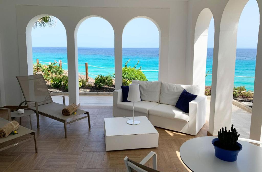 a living room with a white couch and the ocean at Royal Palm Resort & Spa - Adults Only in Playa Jandia