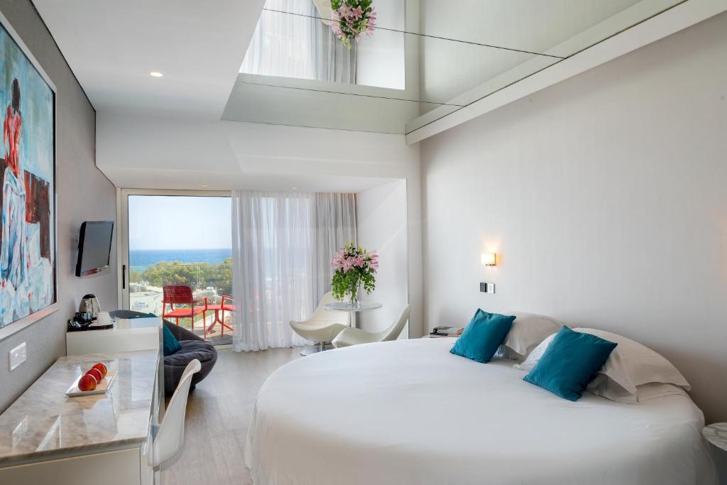 a bedroom with a large white bed and a window at Faros Hotel Ayia Napa in Ayia Napa