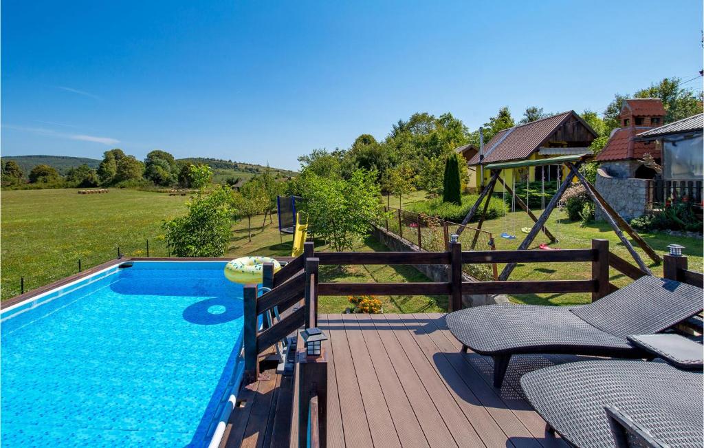 una piscina su una terrazza in legno accanto a una casa di 2 Bedroom Beautiful Home In Plaski a Plaški