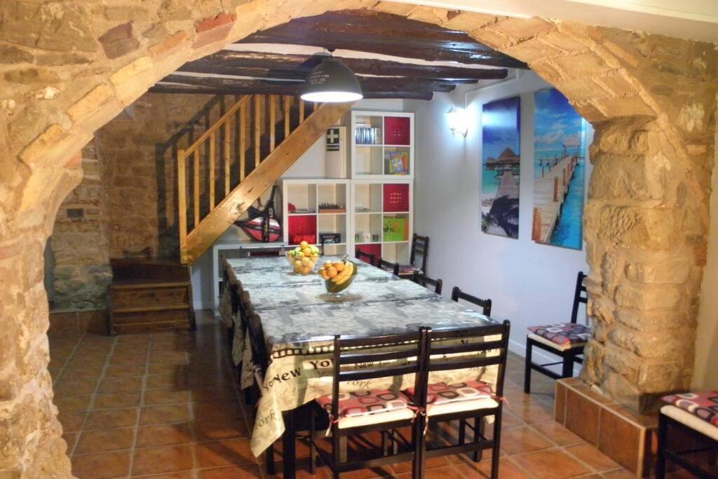 Casa Parra Lazagurria في Lazagurría: غرفة طعام مع طاولة وجدار حجري