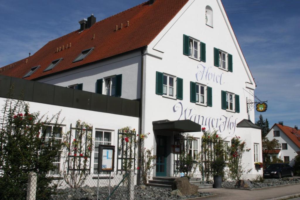 ein weißes Gebäude mit rotem Dach in der Unterkunft Hotel Gasthaus Wangerhof in Augsburg