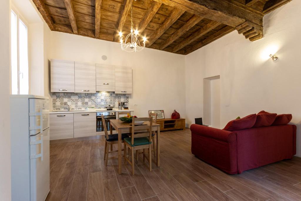 a living room with a table and a red couch at Cocastelli 1 - Smart Holiday in Mantova