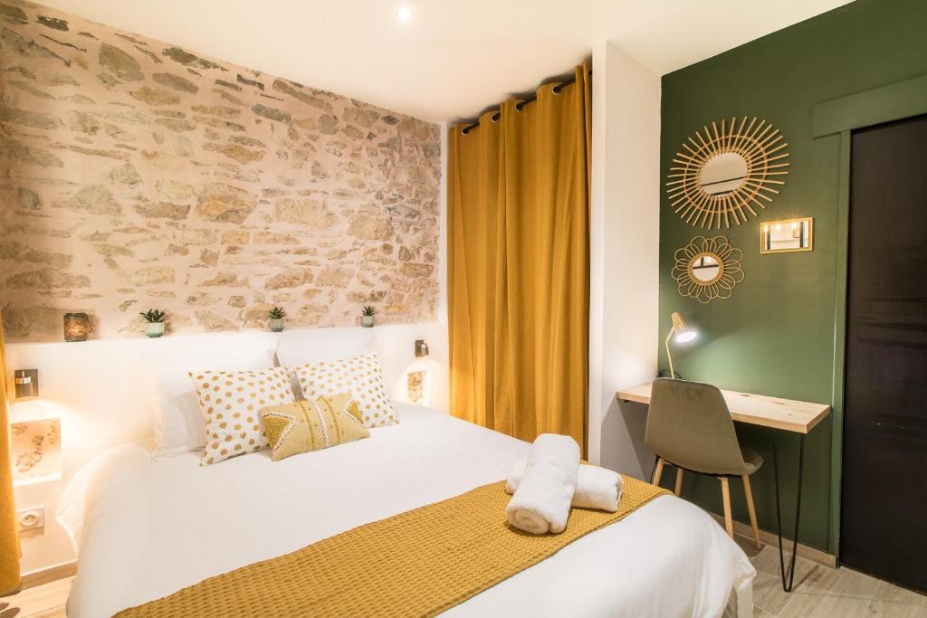 a bedroom with a bed and a desk with a chair at Appartement Cosy Nîmes-Centre in Nîmes