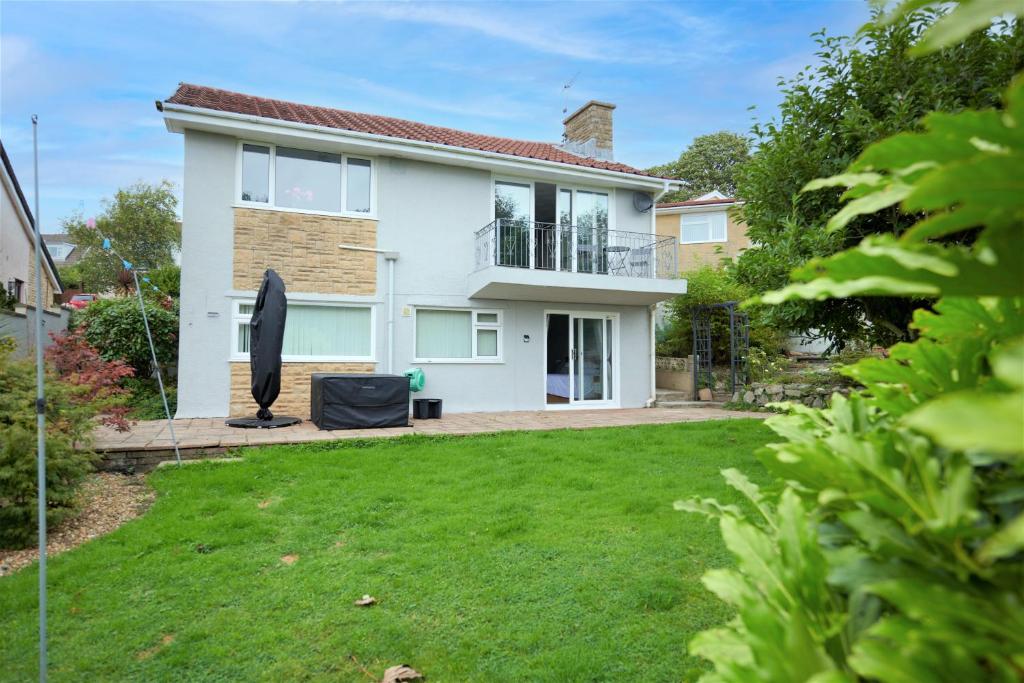 ein weißes Haus mit Rasen davor in der Unterkunft Sea Gem- Beautiful family home with stunning sea views & garden in Tenby