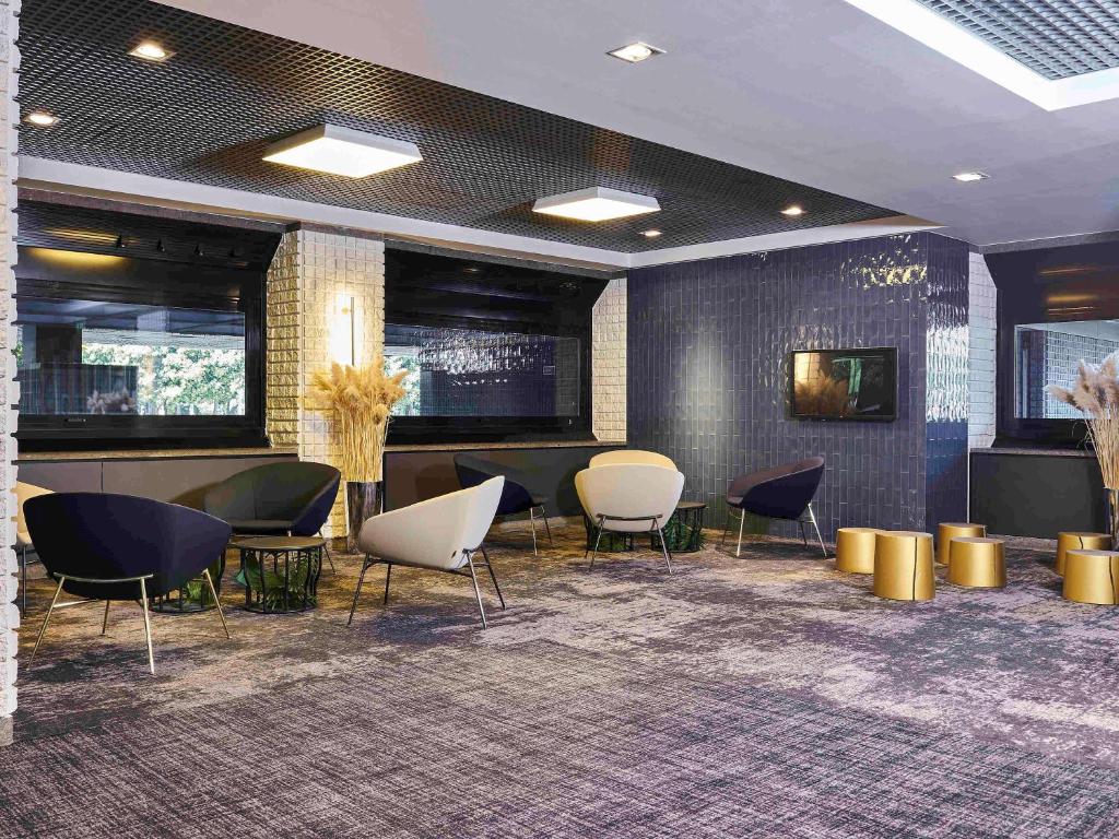 a lobby with chairs and a bar in a building at Novotel Milano Nord Ca' Granda in Milan