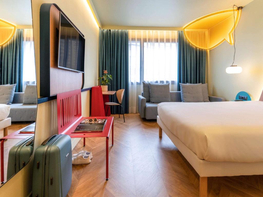Habitación de hotel con cama y sala de estar. en Ibis Styles Madrid City Las Ventas, en Madrid