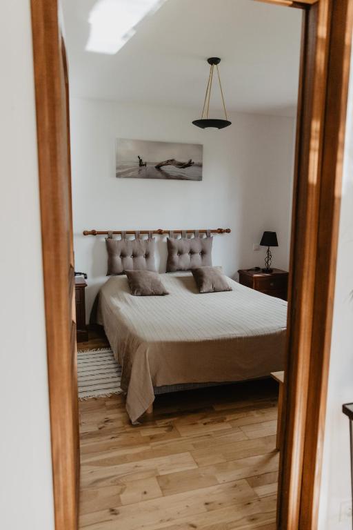 a bedroom with a large bed and a mirror at Hôtel Les Charmilles de Mormal in Landrecies