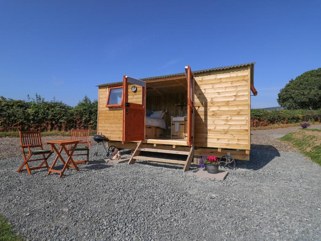 a wooden tiny house with a table and chairs at Claerwen in Llandrindod Wells