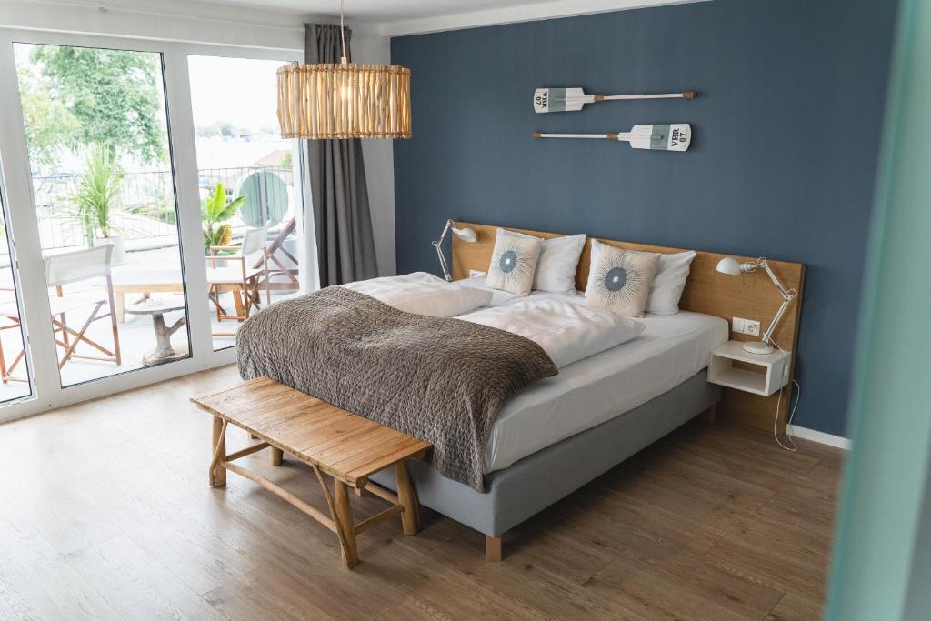 um quarto com uma cama com uma parede azul em QC Hotel Quartier Chiemsee em Seebruck